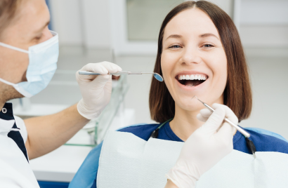 ผู้หญิงยิ้มกว้างโชว์ฟันสวยขณะตรวจฟัน